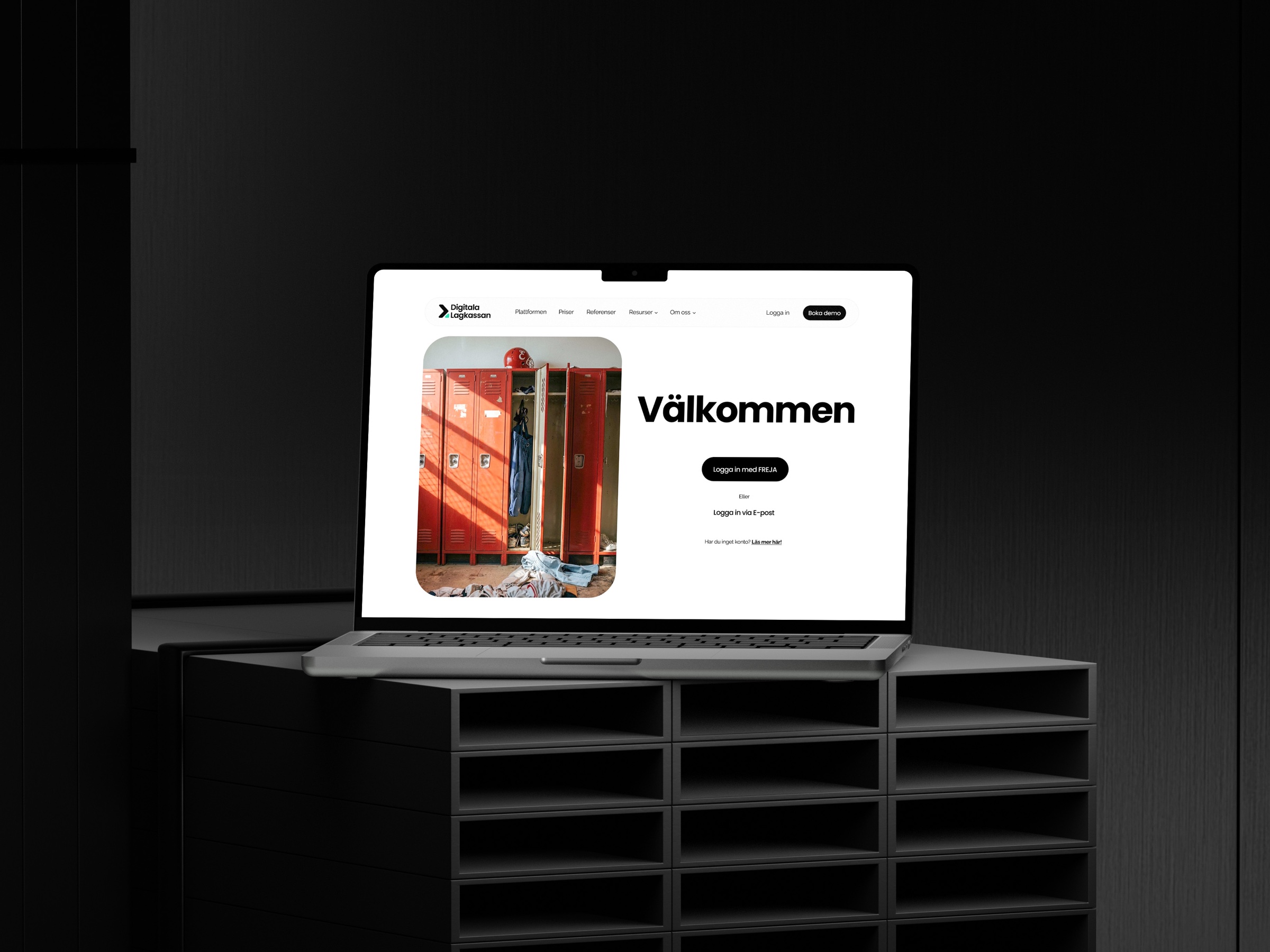 Laptop on dark shelving showing the Digitala Lagkassan login page with red lockers